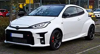 A small front-engined car with three doors, wing mirrors, and alloy wheels