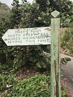 Green and white wooden trailhead sign for Mary’s Point and North Coast Trail