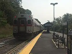 A commuter rail train at a low-platform station