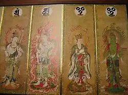 Four deities on four sections of a folding screen. Two of them are female and dressed in robes. The other two are male and only sparely dressed. All four have halos with flames.