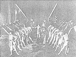 A black-and-white image of a group of young women holding flags on stage