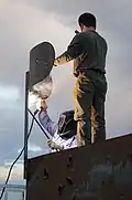 Test services maintenance crewmen weld the support brace of a fake radar dish on the top of a target shaped like a radar van (2010).