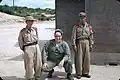 A U.S. soldier poses with North Korean soldiers in this Kodachrome slide from 1956
