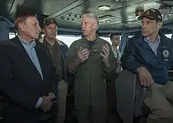 Capt. Karl Thomas, commanding officer of the Nimitz-class aircraft carrier USS Carl Vinson, speaks on 22 October 2014 with U.S. Representatives John Mica, left, from Florida, Juan Vargas, middle, and Darrell Issa, seated, from California, on the navigation bridge. Carl Vinson and its embarked air wing, Carrier Air Wing 17, are deployed in the U.S. 5th Fleet area of operations supporting Operation Inherent Resolve, strike operations in Iraq and Syria as directed, maritime security operations, and theater security cooperation efforts in the region.