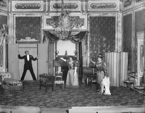 man in evening dress found in a wardrobe by two shocked-looking women