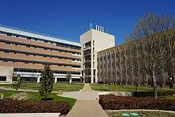 A large, modern building behind a landscaped quadrangle