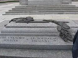 A granite tomb engraved with The Unknown Soldier on the side; a bronze relief sculpture is atop the sarcophagus