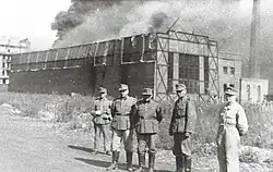 German soldiers in front of a burning Ursus factory