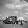 An injured or sick person on a stretcher is loaded into an Austin K2/Y ambulance at a repatriation center in Eindhoven, the Netherlands, 1945.
