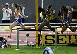 Photo of a row of three runners at the finish line seen from the side