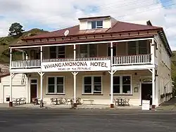 A photo of a two-storey hotel with white sidings and a red roof