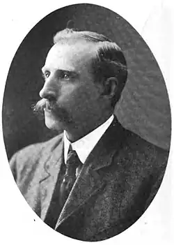 A black and white portrait of William H. Taylor, a man with a mustache, wearing a suit and tie.