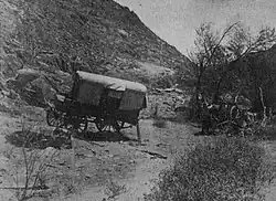 A photograph of a broken down wagon in the African bush country