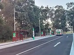 A road with bus shelters on the left