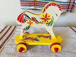 A horse-shaped wooden toy with wheels