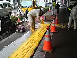 Installation of tactile paving on sidewalk