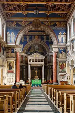 Interior of the church, facing east, showing the truss ceiling and the altar under the ciborium